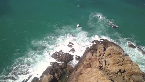 Aerial-tilt-down-shot-of-a-cape-with-the-waves-hitting-the-rocks-in-the-south-of-Spain
