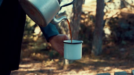 Camper-Gießt-Heißen-Kaffee-In-Die-Tasse