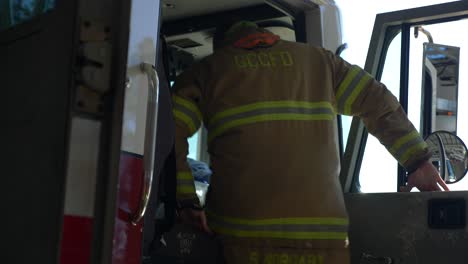 Ein-Feuerwehrmann-Steigt-In-Ein-Feuerwehrauto,-Um-Im-Notfall-Zu-Reagieren-Und-Einen-Brand-Zu-Bekämpfen