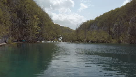 Wunderschöne-Seen-Mit-Wasserfällen-In-Der-Ferne-Und-Touristen,-Die-Sie-Erkunden