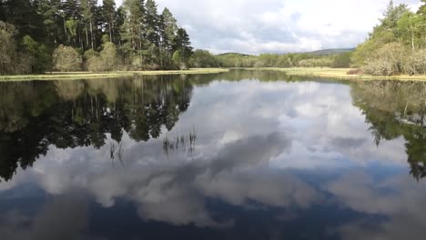 Loch-Kinord-En-Una-Hermosa-Mañana-De-Primavera-Con-Reflejos-De-Nubes