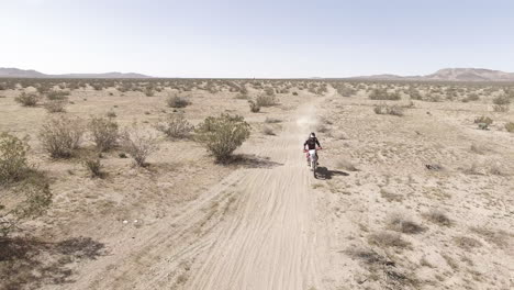 AERIAL:-A-dirt-biker-races-on-his-Honda-CRF-motorcycle-in-the-desert
