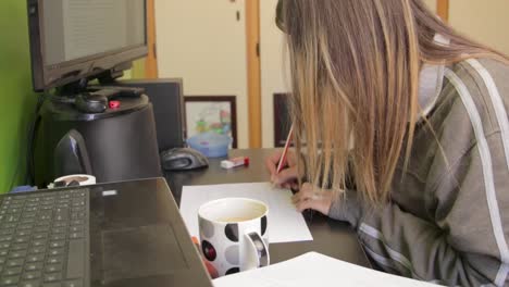 Woman-at-a-desk-writing-on-a-sheet-of-paper-TILT