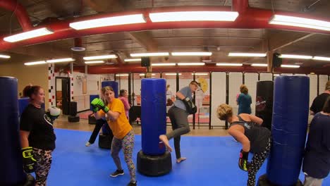 Adult-students-practicing-reverse-kicks-while-participating-in-a-self-defense-class-at-martial-arts-school