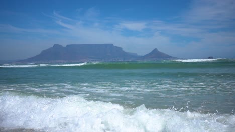 Slowmotion-of-Atlantic-Ocean-Waves-and-Panning-up-to-the-Table-Mountain-in-Capetown-in-Background
