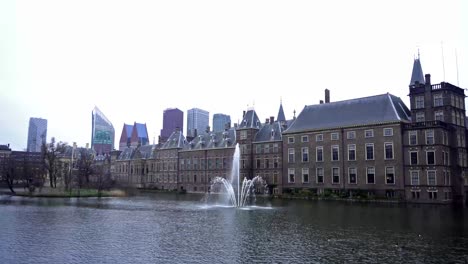 Vista-De-La-Casa-Del-Parlamento-Binnenhof-Y-El-Lago-Hofvijver-Con-Rascacielos-En-El-Fondo