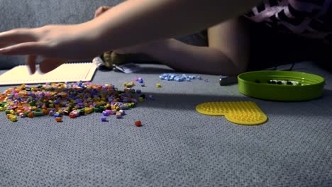 Child-making-art-with-perler-beads,on-the-sofa
