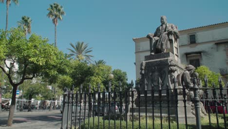 Statue-in-Jerez,-Spain-with-people-and-traffic-passing-by,-Slow-Motion