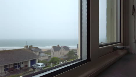 Rain-Flowing-Down-a-Window-with-the-Ocean-Visible-in-the-Background