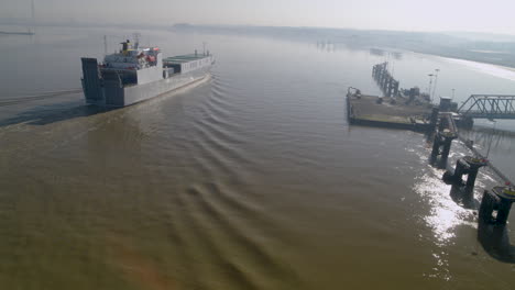 Aerial-view-of-a-cargo-ferry-sailing-down-the-River-Thames,-England