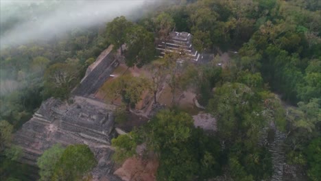 AERIAL-SLOW-MOTION:-Aerial-shot-of-Mayan-ball-park-in-archaeological-site-amid-deep-green-forest-in-Copan-Ruins,-Honduras