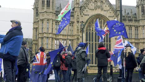 People-protesting-with-flags-about-Brexit-out-Parliament,-London,-UK