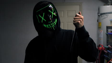 Ein-Furchterregender-Slasher-Killer-In-Einer-Generischen,-Anonymen-Halloween-Horrormaske,-Der-Ein-Messer-Auf-Sein-Mordopfer-Richtet