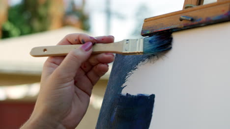 SLOW-MOTION-video-of-female-artist-applying-blue-paint-to-canvas
