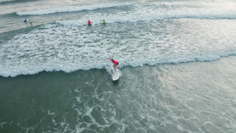 4K-Aerial-Drone-Following-Shot-of-Surfer-Taking-Lesson-in-Tambor,-Costa-Rica