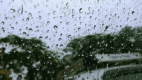 Closeup-focus-of-water-droplets-on-a-car-window-during-heavy-rainfall
