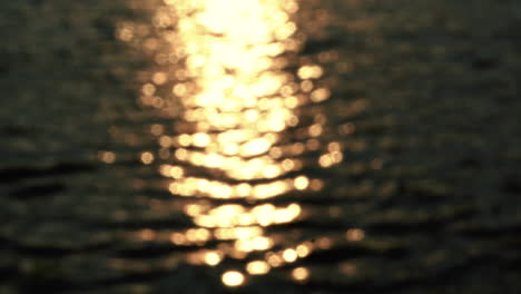 Verschwommenes-Goldenes-Licht,-Das-Auf-Der-Wasseroberfläche-Des-Sees-Reflektiert-Wird