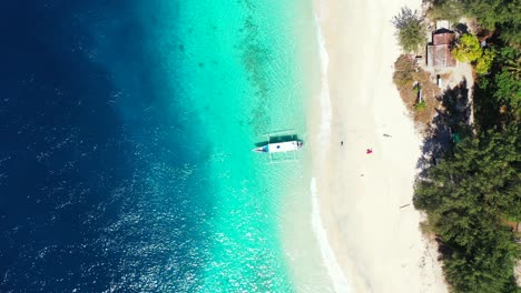 Blick-Von-Oben-Auf-Die-Paradiesische-Küste-Einer-Tropischen-Insel-Mit-Weißem-Sandstrand,-Der-Von-Einer-Blau-türkisen-Lagune-Begrenzt-Wird,-In-Der-Boote-Schwimmen,-Und-üppiger-Vegetation-In-Antigua