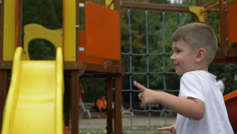 Little-boy-dancing-in-playground-with-smurfs-on-T-shirt,-slow-motion