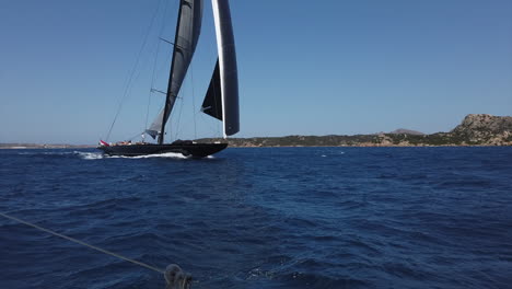 A-giant-black-sailing-boat-sails-at-La-Maddalena-National-Park,-Sardinia