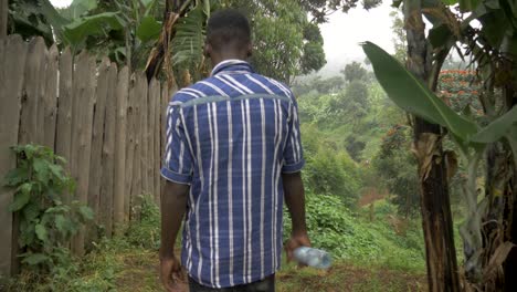 Slow-motion-tracking-shot-following-two-African-men-walking-through-the-lush-green-rural-areas-of-East-Africa