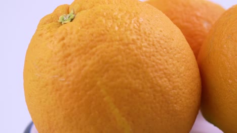 Close-Up-Frische-Valencia-Orange-In-Scheiben-Geschnitten-Mit-Weißem-Hintergrund-Flachen-Fokus-Und-Langsam-Drehen