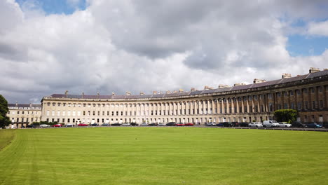 Slow-Motion-Left-to-Right-Pan-Shot-of-The-Royal-Crescent-in-Bath,-Somerset-on-a-Sunny-Summer’s-Day-with-Blue-Sky-and-White-Clouds