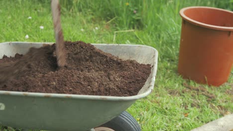 Mixing-soil-in-wheelbarrow-with-shovel-gardening