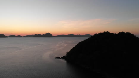 Silhouette-Of-Coastal-Mountains-By-The-Calm-Sea-Coast-During-Sunset-In-El-Nido,-Palawan,-Philippines