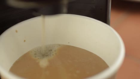 Coffee-machine-filling-paper-cup-close-up-shot