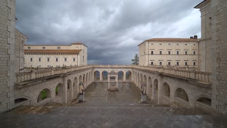 Empty-and-desolate-courtyard-at-abbey-of-Montecassino-with-arches-monumental-structure-with-ominous-eerie-grey-sky,-Italy,-covid-19-pandemic,-static
