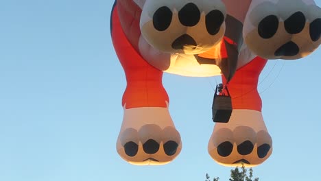 Ein-Hundeförmiger-Heißluftballon-Mit-Einer-Lebendigen-Flamme,-Die-Den-Ballon-über-Einer-Wunderschönen-Stadt-Fliegen-Lässt