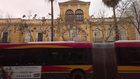 Tilt-Down,-Yellow-building-Jardines-del-Valle-primary-school-in-Seville,-Spain