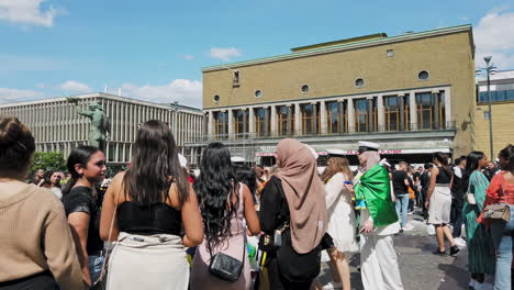 Enthusiastic-young-group-of-women-celebrates-graduation-in-Götaplatsen's-square,-Gothenburg,-Sweden,-Handheld