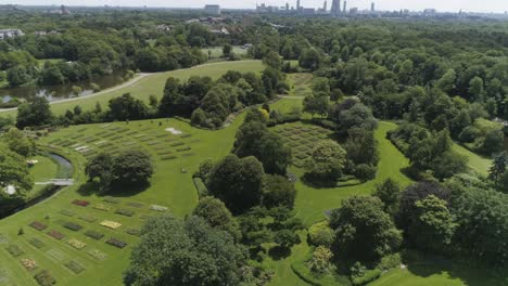 Drone-Slowmotion-of-a-Dutch-Flowerpark-in-The-Hague-during-Sunny-Weather,-with-The-Hague-in-the-background