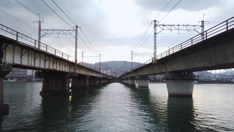 Two-Railway-bridges-crossing-river,-slow-tilt-up
