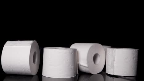 Rolls-of-Toilet-Paper-Falling-in-Abundance,-Black-Background-Slow-Motion