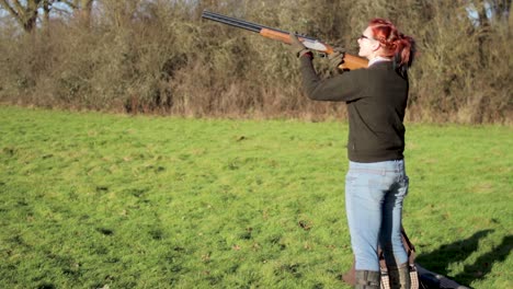 A-girl-with-red-hair-fires-a-shotgun-into-the-air