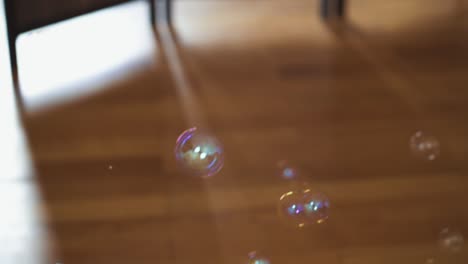 Big-and-small-soap-bubbles-rising-up-from-the-brown-wooden-parquet