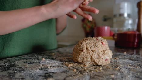 Woman-hands-putting-together-ball-of-dough-and-wiping-it-from-her-fingers