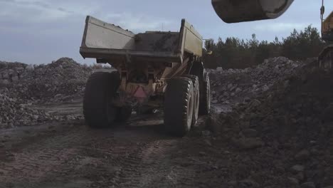 Articulated-Truck-getting-loaded-with-gravel,-Heavy-duty-machinery,-SLOW-MOTION