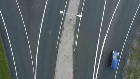 Top-down-aerial-view-in-the-middle-of-a-motorway-in-Finland-near-Helsinki-as-cars-quickly-pass-through-the-frame