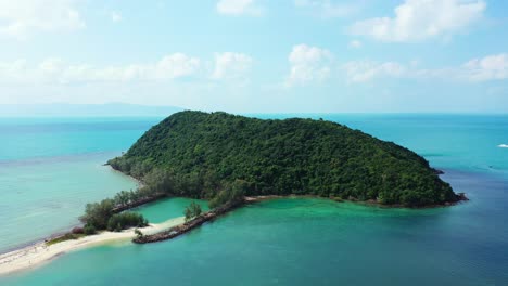 Isla-Tropical-Paradisíaca-Con-Vegetación-Exuberante-Y-Bosque-De-árboles-En-Medio-De-Una-Laguna-Azul-Turquesa-En-Un-Cielo-Nublado-Brillante