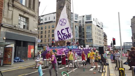 Extinction-Rebellion-protesters-playing-and-dancing-to-music-in-front-of-a-purple-boat-that-is-blocking-off-one-of-the-main-roads-in-Glasgow-city-centre