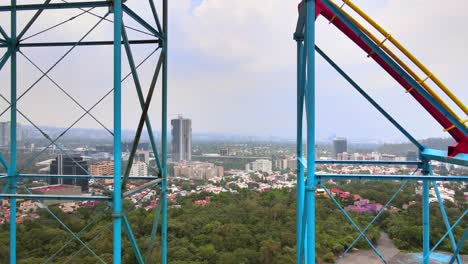Aerial-flying-through-rollercoaster-in-reverse-Mexico-City-skyline-six-flags