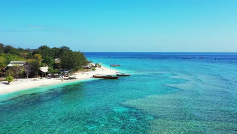 Wunderschöne,-Farbenfrohe-Meeresoberfläche-Mit-Lebendigem-Türkisfarbenem-Wasser,-Das-Den-Weißen-Sand-Eines-Exotischen-Strandes-Auf-Einer-Grünen-Tropischen-Insel-In-Indonesien-Wäscht