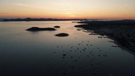 Panoramalandschaft-Mit-Booten-In-Der-Marina-Bay,-Meer,-Lichter-Der-Stadt,-Berge,-Blauer-Himmel-In-Der-Abenddämmerung