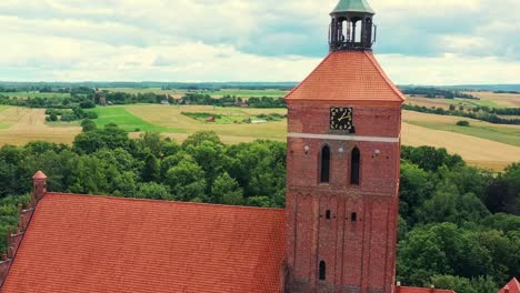 Drone-view-on-clock-tower-by-the-renovated,-historic-church