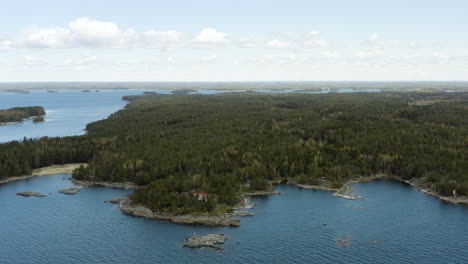 Aerial,-pan,-drone-shot-of-a-large-island-at-the-Gulf-of-Finland,-on-a-sunny-day,-in-the-Porvoo-archipelago,-in-Uusimaa