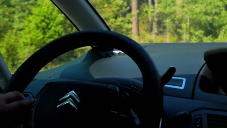 Driving-a-Citroen-car-with-hand-on-steering-wheel-with-a-visible-Citroen-logo